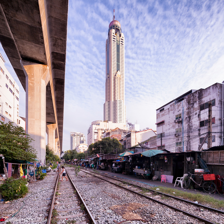 railroad track
 rich and poor
 Bangkok
 Thailand
 Bridge
 skyscrapers
 cabins
