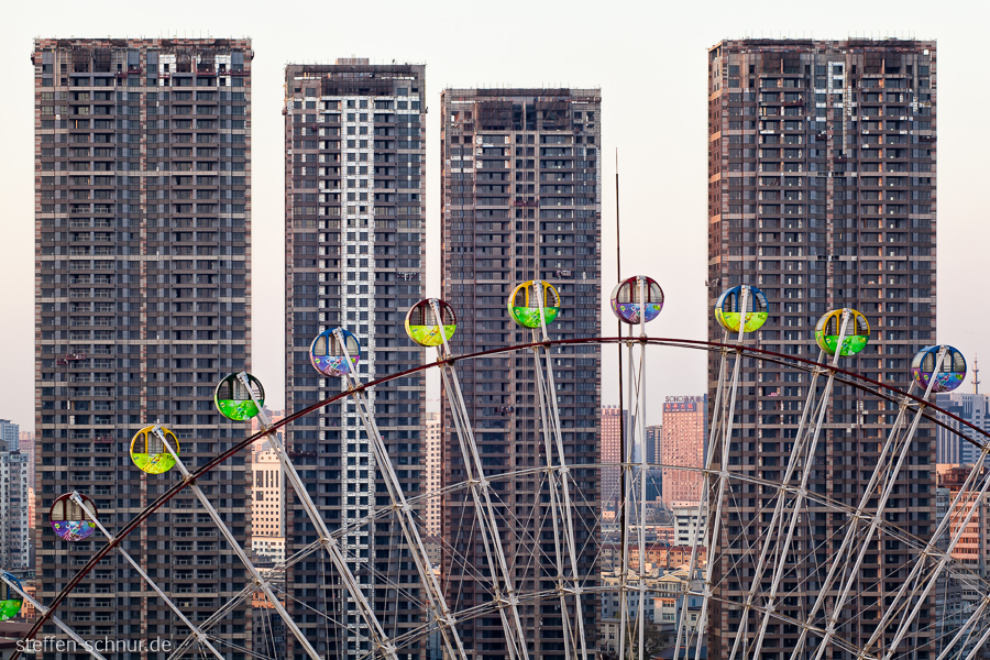 big wheel
 Shenyang
 China
 building lot
 gondolas
 skyscrapers
 from above
