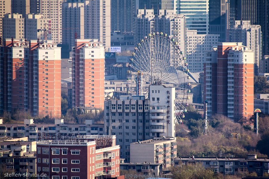 city skyline
 big wheel
 Shenyang
 China
 skyscrapers
 amusement park
 elevated view
