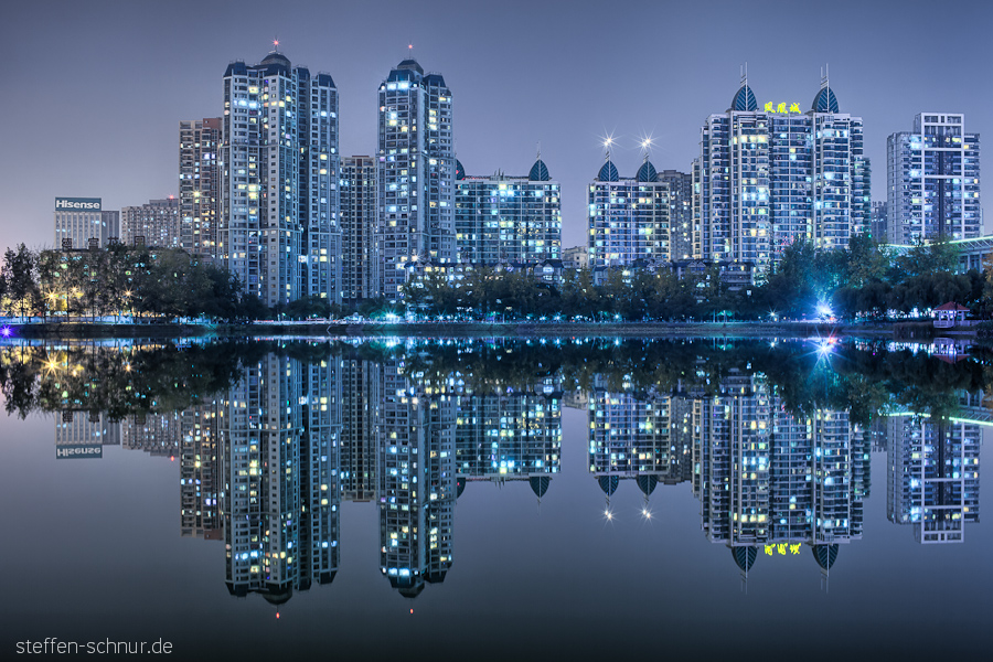 Wuhan China Bäume Hochhäuser Lichter Nachtaufnahme See