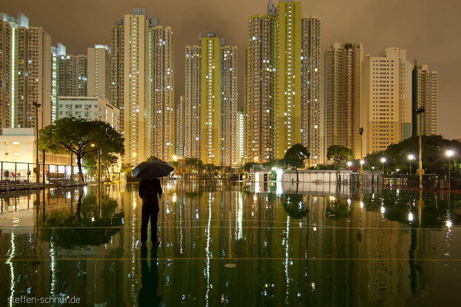 Sportplatz Regenschirm Hongkong China Baum Hochhäuser Person