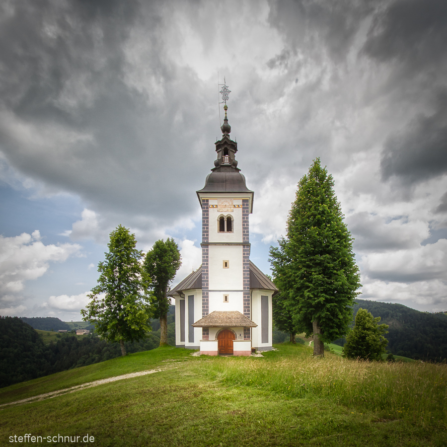 Kirche Slowenien Baum dunkle Wolken
